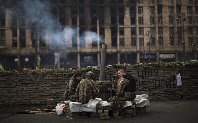Anti-Yanukovych protesters wearing fatigues guard a barricade in Kiev's Independence Square, the epicenter of the country's current unrest, Ukraine, on Saturday, March 1, 2014. (photo credit: AP Photo/Emilio Morenatti) Anti-Yanukovych protesters wearing fatigues guard a barricade in Kiev's Independence Square, the epicenter of the country's current unrest, Ukraine, on Saturday, March 1, 2014. (photo credit: AP Photo/Emilio Morenatti)