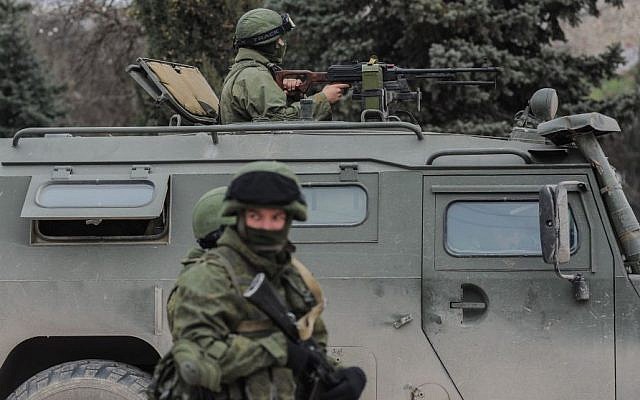 Troops in unmarked uniforms stand guard in Balaklava on the outskirts of Sevastopol, Ukraine, Saturday, March 1, 2014. An emblem on one of the vehicles and their number plates identify them as belonging to the Russian military. (Photo credit: Andrew Lubimov/AP) Troops in unmarked uniforms stand guard in Balaklava on the outskirts of Sevastopol, Ukraine, Saturday, March 1, 2014. An emblem on one of the vehicles and their number plates identify them as belonging to the Russian military. (Photo credit: Andrew Lubimov/AP)