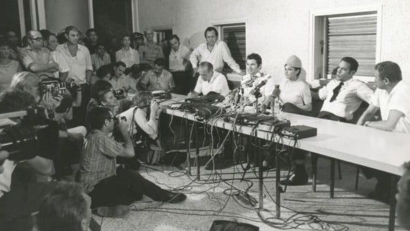 Uri Bar-Lev (with tie) and colleagues speak to the media on their safe return to Israel (photo credit: Courtesy El Al archive)