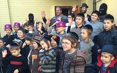 Rabbi Yechiel Eckstein (back row in blue shirt flanked by masked security guards), founder and president of the International Fellowship of Christians and Jews, on a visit to a Kiev school during a Ukraine fact-finding mission. (Eva Geller)
