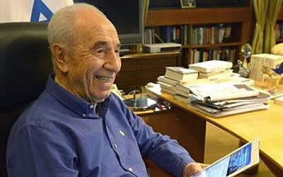 Equipped with an iPad, then-president Shimon Peres prepares to answer questions posed to him on Facebook, March 2014. (Photo credit: Courtesy)