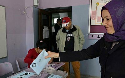 A Turkish woman casts her ballot at a polling station in Ankara Turkey, Sunday, March 30, 2014. (photo credit: AP/Burhan Ozbilici)