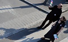 A couple walk with the Hungarian and Israeli flags in Budapest on April 27, 2014, during a march commemorating the 70th anniversary of the Holocaust (photo credit: AFP/Attila Kisbenedek)