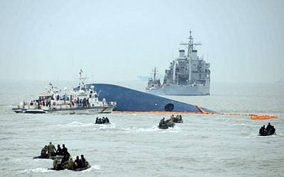 Coast guard members search for passengers near a South Korean ferry that capsized on its way to Jeju island from Incheon, at sea some 20 kilometers off the island of Byungpoong in Jindo on April 17, 2014. (photo credit: AFP PHOTO/ ED JONES)