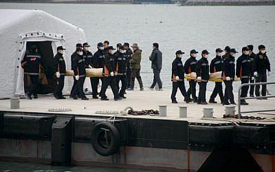 The bodies of victims recovered from the "Sewol" ferry are carried to waiting ambulances at Jindo harbor on April 22, 2014. (photo credit: AFP Photo/Ed Jones)