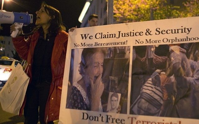Israeli protestors hold signs during a demonstration outside US Secretary of State John Kerry's hotel in Jerusalem, against the planned release by Israel of Palestinian prisoners, Monday, March 31, 2014 (photo credit: Ahmad Gharabli/AFP) Israeli protestors hold signs during a demonstration outside US Secretary of State John Kerry's hotel in Jerusalem, against the planned release by Israel of Palestinian prisoners, Monday, March 31, 2014 (photo credit: Ahmad Gharabli/AFP)
