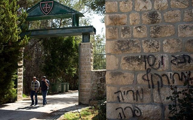 People leave the Deir Rafat Catholic convent whose walls can be seen sprayed with graffiti reading 'Jesus is a monkey,' Mary is a cow,' and 'price tag,' Tuesday, April 1, 2014, near the Israeli city of Beit Shemesh (photo credit: AFP/Menahem Kahana) People leave the Deir Rafat Catholic convent whose walls can be seen sprayed with graffiti reading 'Jesus is a monkey,' Mary is a cow,' and 'price tag,' Tuesday, April 1, 2014, near the Israeli city of Beit Shemesh (photo credit: AFP/Menahem Kahana)