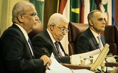 Palestinian Authority President Mahmoud Abbas, center, and negotiator Saeb Erekat, left, attend the Arab foreign ministers' meeting at the Arab League headquarters in Cairo, on April 9, 2014. (photo credit:  AFP PHOTO / MOHAMED EL-SHAHED)