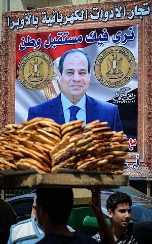 Egyptians walk past a poster bearing a portrait of retired army chief and presidential candidate Abdel Fattah al-Sisi on April 12, 2014 in the capital Cairo. (photo credit: AFP Photo/Mohamed el-Shahed) Egyptians walk past a poster bearing a portrait of retired army chief and presidential candidate Abdel Fattah al-Sisi on April 12, 2014 in the capital Cairo. (photo credit: AFP Photo/Mohamed el-Shahed)