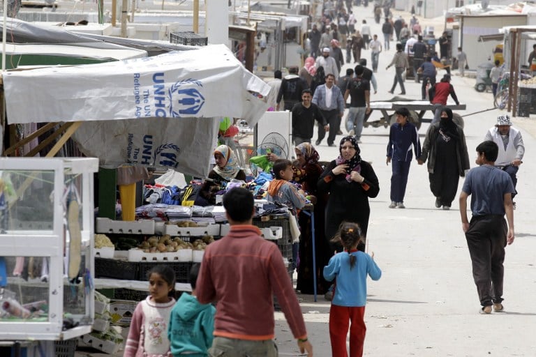 Syrian refugees walks past a makeshift market in the Zaatari refugee camp, on April 15, 2014. (photo credit: AFP/Khalil Mazraawi) Syrian refugees walks past a makeshift market in the Zaatari refugee camp, on April 15, 2014. (photo credit: AFP/Khalil Mazraawi)