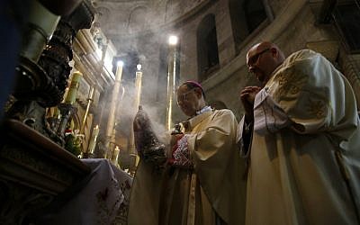 The Latin Patriarch of Jerusalem and Head of the Roman Catholic Church in the Holy Land, Fuad Twal (C), leads an Easter Sunday mass in the Church of Holy Sepulchre in Jerusalem's Old City on April 20, 2014.  (photo credit: AFP PHOTO/GALI TIBBON)
