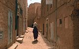 A Moroccan woman carries a sack on her head as she walks along a narrow street in the Jewish Mellah quarter of Tinghir, at the foot of the High Atlas and the heart of Morocco's Berber community on April 21 , 2014 (photo credit: AFP/FADEL SENNA)