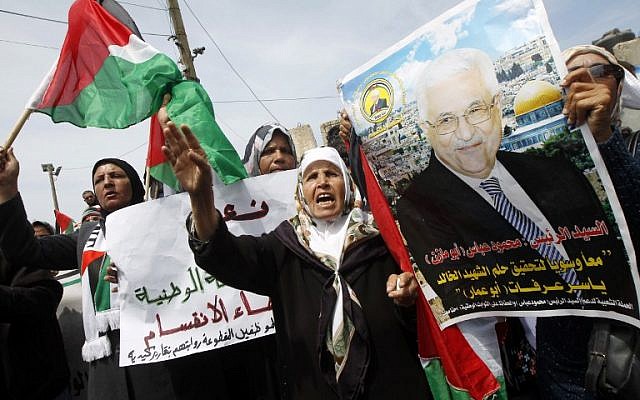 Palestinians shout slogans and hold a portrait of Palestinian president Mahmoud Abbas as they take part in a demonstration in support of a new attempt to reconcile Hamas and the PLO in Gaza City Wednesday. (photo credit: AFP/SAID KHATIB)