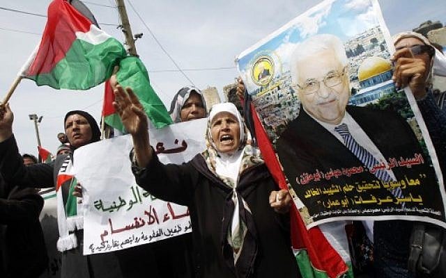 Palestinians shout slogans and hold a portrait of Palestinian leader Mahmoud Abbas (portrait) as they take part in a demonstration in support of a new attempt to reconcile the militant Islamist movement Hamas and its Palestine Liberation Organisation (PLO) April 23, 2014. (photo credit: AFP/SAID KHATIB) Palestinians shout slogans and hold a portrait of Palestinian leader Mahmoud Abbas (portrait) as they take part in a demonstration in support of a new attempt to reconcile the militant Islamist movement Hamas and its Palestine Liberation Organisation (PLO) April 23, 2014. (photo credit: AFP/SAID KHATIB)