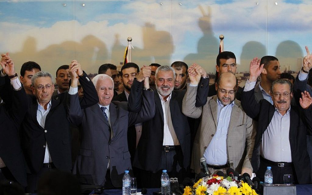 File: From left: Palestinian legislator Mustafa Barghouti, Palestinian Fatah delegation chief Azzam al-Ahmed, Hamas prime minister in the Gaza Strip Ismail Haniyeh, Hamas deputy leader Musa Abu Marzuk, and secretary-general of the Palestinian Arab Front  Jameel Shehadeh, pose for a picture in Gaza on April 23, 2014 after announcing a unity deal. (photo credit:AFP/SAID KHATIB)