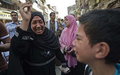 Egyptians react outside the courtroom in Egypt's southern province of Minya on April 28, 2014.  (photo credit:AFP/KHALED DESOUKI)