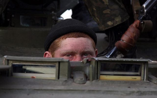 A soldier peeks out as a column of Ukrainian men on Armoured Personnel Carriers were blocked by pro-Russia supporters in the eastern Ukrainian city of Kramatorsk on April 16, 2014.  (AFP/ANATOLIY STEPANO)