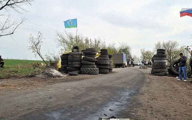 Armed pro-Russian militants stand guard at a check-point outside the eastern Ukrainian city of Slavyansk, on April 20, 2014. (photo credit: AFP Photo/Genya Savilov) Armed pro-Russian militants stand guard at a check-point outside the eastern Ukrainian city of Slavyansk, on April 20, 2014. (photo credit: AFP Photo/Genya Savilov)