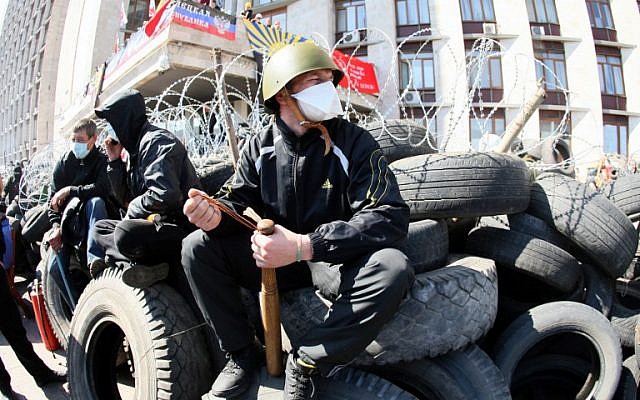 A pro-Russian militant holding a bat guards a barricade in front of the Donetsk regional administration building on April 8, 2014. (photo credit: AFP PHOTO / ALEXANDER KHUDOTEPLY) A pro-Russian militant holding a bat guards a barricade in front of the Donetsk regional administration building on April 8, 2014. (photo credit: AFP PHOTO / ALEXANDER KHUDOTEPLY)