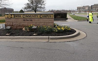 An Overland Park police officer and Kansas State Trooper guard the entrance of the Jewish Community Center after a gunman opened fire in Overland Park, Kan., Sunday, April 13, 2014. (photo credit: AP Photo/Orlin Wagner)