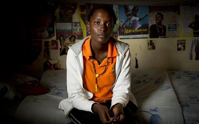 Student Sharon Kalisa, 17, whose favorite subject is history and particularly genocide studies, sits in her bedroom at the Agahozo-Shalom Youth Village. (AP Photo/Ben Curtis)