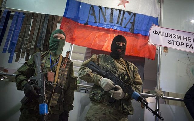 Masked pro-Russian gunmen guard an entrance to the Ukrainian regional office of the Security Service, with a Russian National flag in the background, in Luhansk, Ukraine, Monday, April 21, 2014 (photo credit: AP/Alexander Zemlianichenko) Masked pro-Russian gunmen guard an entrance to the Ukrainian regional office of the Security Service, with a Russian National flag in the background, in Luhansk, Ukraine, Monday, April 21, 2014 (photo credit: AP/Alexander Zemlianichenko)