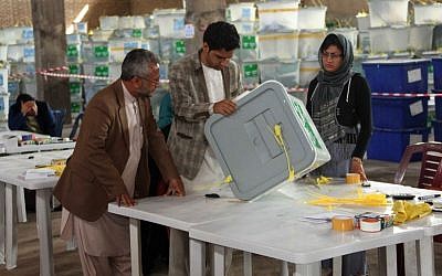 Afghan ballot counters read instructions on how to count and register votes in Herat Province, west of Kabul, Afghanistan, Sunday, April 20, 2014. (AP Photo/Hoshang Hashimi)