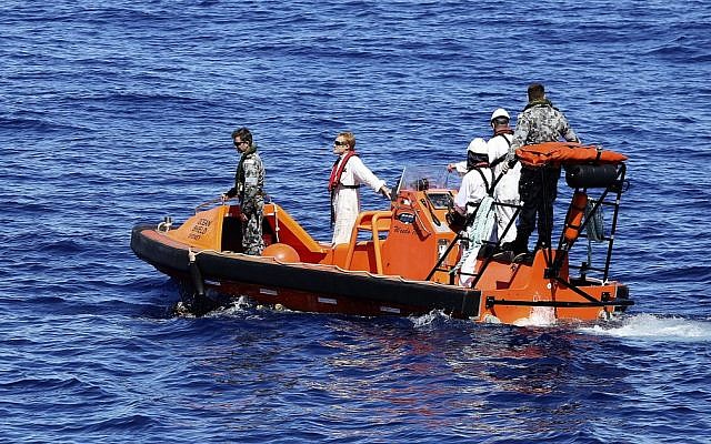 In this April 7, 2014 photo provided by the Australian Defense Force, a fast response craft manned by members from the Australian Defense's ship Ocean Shield tows Able Seaman Clearance Diver Michael Arnold as they scan the water for debris of the missing Malaysia Airlines Flight 370 in the southern Indian Ocean.  (photo credit: AP/Australian Defense Force, LSIS Bradley Darvill)