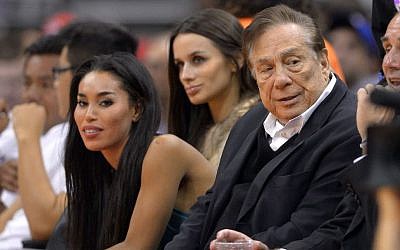 Los Angeles Clippers owner Donald Sterling, right, and V. Stiviano, left, watch the Clippers play the Sacramento Kings in Los Angeles in October, 2013.  (photo credit: AP/Mark J. Terrill)