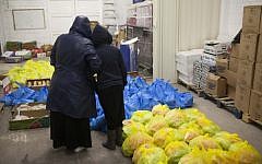 A mother and her daughter stand inside a food distribution center for the needy, in Jerusalem on March 7, 2013 (photo credit: Yonatan Sindel/Flash90)