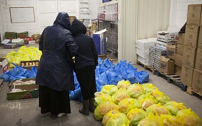 A mother and her daughter stand inside a food distribution center for the needy, in Jerusalem on March 7, 2013 (photo credit: Yonatan Sindel/Flash90)