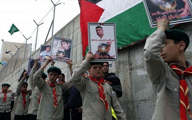 Palestinian youth hold placards during a solidarity rally for Palestinian prisoners in Israeli jails, organized by Hamas, in the Shuafat refugee camp, Jerusalem on April 19, 2013. (photo credit: Sliman Khader/Flash90) Palestinian youth hold placards during a solidarity rally for Palestinian prisoners in Israeli jails, organized by Hamas, in the Shuafat refugee camp, Jerusalem on April 19, 2013. (photo credit: Sliman Khader/Flash90)