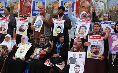 Palestinians take part in a protest demanding the release of their relatives held in Israeli jails, in front of the Red Cross office in the West Bank city of Ramallah, on April 15, 2014. (Photo credit: Issam Rimawi/FLASH90)