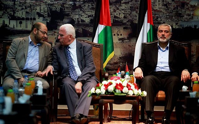 Senior Hamas leader Moussa Abu Marzouk (L) and Azzam Al-Ahmed, a senior Fatah official talk during their meeting in Gaza City on April 22, 2014. At right is Hamas Prime Minister Ismail Haniyeh. (photo credit: Abed Rahim Khatib/Flash90)