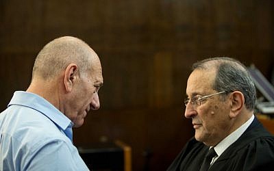 Former prime minister Ehud Olmert speaks with his attorney Eli Zohar in the courtroom of the District Court in Tel Aviv during the sentencing hearings in the Holyland trial on April 29, 2014.  (photo credit: Ben Kelmer/POOL/Flash90)