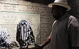 Ilan Goodman, curator at the Chamber of the Holocaust, points out a uniform from a concentration
camp, one of the items housed at the chamber. (Photo credit: Rebecca McKinsey/The Times of Israel)