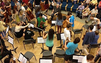 Violinist and conductor Itzhak Perlman tells his students to switch places in order to play a piece of Mozart (photo credit: Jessica Steinberg/Times of Israel)