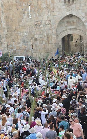 As Holy Week begins, a crowd of people carries palm fronds down from the Mount of Olives into the  Old City to commemorate Jesus' entry into Jerusalem a week before his crucifixion. (photo credit: Rebecca McKinsey/The Times of Israel)