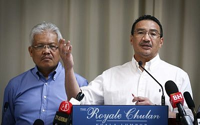 Malaysian Deputy Minister of Foreign Affairs Hamzah Zainudin, left, listens as Malaysia's acting Transport Minister Hishammuddin Hussein answers a question from a journalist during a press conference on the missing Malaysia Airlines Flight 370 at a hotel in Kuala Lumpur, Malaysia, Saturday, April 19, 2014 (photo credit: AP/Vincent Thian)