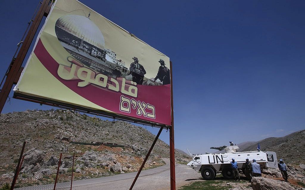 Indian UN peacekeepers with their armored personnel carrier, right, stand guard next to a giant poster that shows Hezbollah fighters and the Al Aqsa Mosque with Arabic and Hebrew words reading: "We are coming," near the barbed wire that separates Lebanon from the Shebaa Farms. April 16, 2014. AP/Hussein Malla) Indian UN peacekeepers with their armored personnel carrier, right, stand guard next to a giant poster that shows Hezbollah fighters and the Al Aqsa Mosque with Arabic and Hebrew words reading: "We are coming," near the barbed wire that separates Lebanon from the Shebaa Farms. April 16, 2014. AP/Hussein Malla)