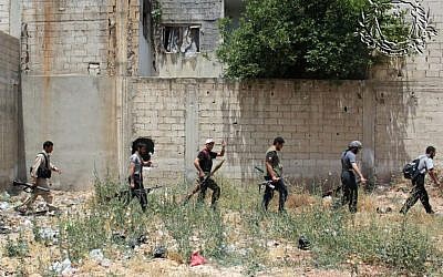 Syrian rebels holding their weapons as they prepare to fight against Syrian troops, in Homs province, Syria, June 18, 2012 . (photo credit: AP/Rebels Battalion of Baba Amro)