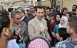 Syrian President Bashar Assad (center), speaks with Syrian citizens during his visit to Ain al-Tineh village, near Damascus, Syria, on April 20, 2014. (photo credit: AP/SANA)