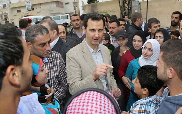 Syrian President Bashar Assad (center), speaks with Syrian citizens during his visit to Ain al-Tineh village, near Damascus, Syria, on April 20, 2014. (photo credit: AP/SANA) Syrian President Bashar Assad (center), speaks with Syrian citizens during his visit to Ain al-Tineh village, near Damascus, Syria, on April 20, 2014. (photo credit: AP/SANA)