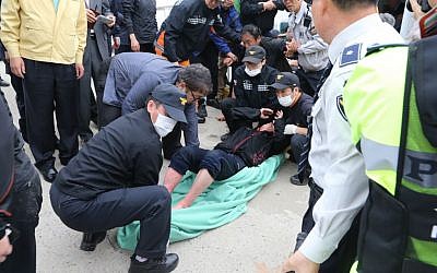 A rescued passenger from a ferry sinking off South Korea's southern coast is carried by police and rescue teams on his arrival at Jindo port in Jindo, south of Seoul, South Korea, Wednesday, April 16, 2014 (photo credit: AP/Park Chul-heung, Yonhap)