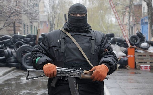 A pro-Russian gunman stands guard at a seized police station in the eastern Ukraine town of Slovyansk on Sunday, April 13, 2014. (photo credit: AP/Efrem Lukatsky)