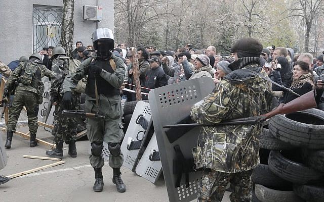 Armed pro-Russian activists occupy the police station carrying riot shields as people watch on, in the eastern Ukraine town of Slovyansk on Saturday, April 12, 2014. Pro-Moscow protesters have seized a number of government buildings in the east over the past week, undermining the authority of the interim government in the capital, Kiev. (photo credit: AP/Efrem Lukatsky) Armed pro-Russian activists occupy the police station carrying riot shields as people watch on, in the eastern Ukraine town of Slovyansk on Saturday, April 12, 2014. Pro-Moscow protesters have seized a number of government buildings in the east over the past week, undermining the authority of the interim government in the capital, Kiev. (photo credit: AP/Efrem Lukatsky)