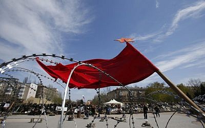 A flag flutters in the wind over barricades at the regional administration building that has been seized earlier in Donetsk, Ukraine, Friday, April 18, 2014. Pro-Russian insurgents in Ukraine’s east who have been occupying government buildings in more than 10 cities said Friday they will only leave them if the interim government in Kiev resigns.(photo credit: AP/Sergei Grits)