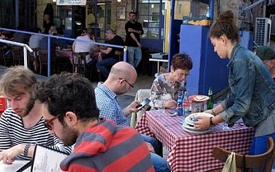 In this photo taken Wednesday, March, 26, 2014, diners enjoy a meal at the Azura restaurant in Jerusalem's Mahane Yehuda market. (photo credit: AP Photo/Aron Heller) In this photo taken Wednesday, March, 26, 2014, diners enjoy a meal at the Azura restaurant in Jerusalem's Mahane Yehuda market. (photo credit: AP Photo/Aron Heller)