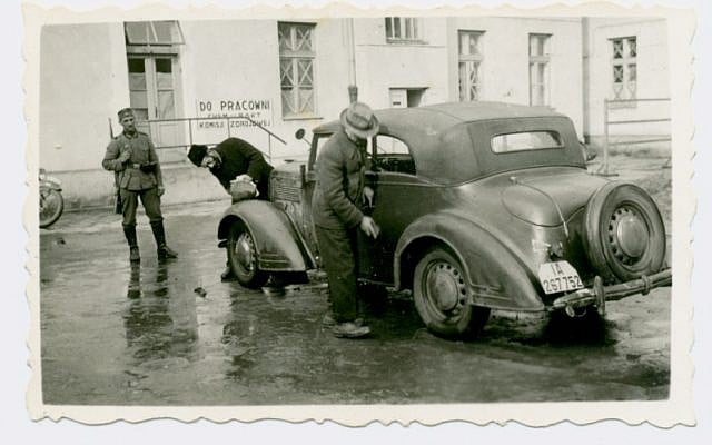 Jews forced to wash vehicles a soldier looks on, Poland. (photo credit: Shem Olam Institute)