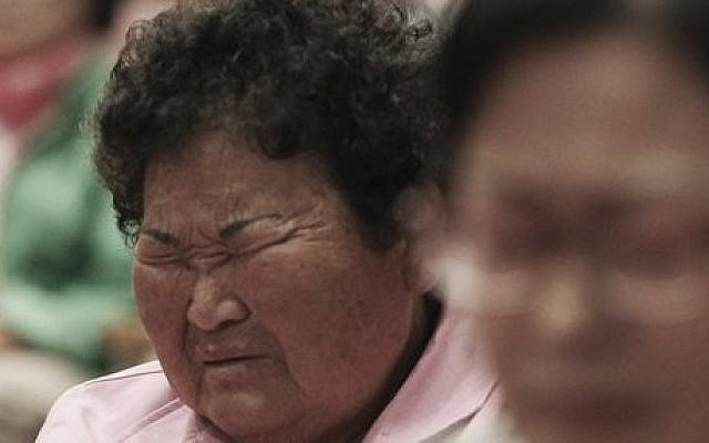 A local resident closes her eyes during a prayer to wish for safe return of passengers of the sunken ferry Sewol during an annual Easter service in Jindo, South Korea, Sunday, April 20, 2014.  (photo credit: AP Photo/Ahn Young-joon)